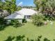 Backyard featuring a well-manicured lawn, lush landscaping, and outdoor seating area at 337 Meadow Beauty Ct, Venice, FL 34293