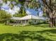 Lush backyard with a well-maintained lawn, mature trees, and a cozy seating arrangement at 337 Meadow Beauty Ct, Venice, FL 34293