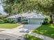 Beautiful home featuring a well-manicured lawn, lush landscaping, and a two-car garage at 337 Meadow Beauty Ct, Venice, FL 34293