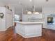 Open kitchen with an island, hardwood floors, and modern white cabinetry at 337 Meadow Beauty Ct, Venice, FL 34293