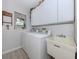 Well-equipped laundry room with white cabinets, sink, and washer/dryer at 337 Meadow Beauty Ct, Venice, FL 34293