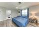 Bright bedroom with gray walls, ceiling fan, blue bedding, and an ensuite bathroom at 3376 Peace River Dr, Punta Gorda, FL 33983