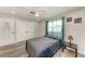 Bedroom with double door closet, window with curtains and wood-look floors at 3376 Peace River Dr, Punta Gorda, FL 33983
