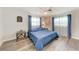 Bedroom featuring a blue bedspread, wood-look flooring, and white ceiling fan at 3376 Peace River Dr, Punta Gorda, FL 33983