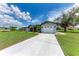 Exterior of lovely home featuring an expansive driveway leading up to the detached garage at 3376 Peace River Dr, Punta Gorda, FL 33983