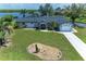 Charming home with a manicured lawn, mature trees, and waterfront views from the front yard at 3376 Peace River Dr, Punta Gorda, FL 33983