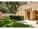 Townhome exterior with well-maintained lawn, greenery, and tan facade at 3633 Parkridge Cir # 10-201, Sarasota, FL 34243