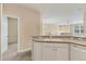 Bright kitchen featuring white cabinetry, a sink, and open access to the living area at 3633 Parkridge Cir # 10-201, Sarasota, FL 34243
