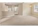 Spacious living area with a partial kitchen view, neutral carpet, and natural light at 3633 Parkridge Cir # 10-201, Sarasota, FL 34243
