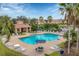 Community pool with patio and seating areas surrounded by tropical landscaping and lake views at 3633 Parkridge Cir # 10-201, Sarasota, FL 34243