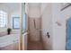 Tiled shower with glass door, soaking tub and tiled walls in bright bathroom at 4308 Via Del Santi, Venice, FL 34293