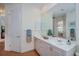 Bright bathroom featuring double sinks, large mirror and access to other rooms at 4308 Via Del Santi, Venice, FL 34293
