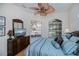 Well-lit bedroom with rattan furniture, ceiling fan, tile floor and large windows at 4308 Via Del Santi, Venice, FL 34293