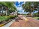 Elegant gated entrance with brick-paved road and lush landscaping, providing security and curb appeal at 4308 Via Del Santi, Venice, FL 34293