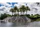 Beautiful waterfall feature with towering palm trees in the Venetia community, creating a serene landscape at 4308 Via Del Santi, Venice, FL 34293