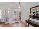 Inviting foyer with decorative glass doors, a console table, and a stylish mirror at 4308 Via Del Santi, Venice, FL 34293