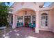 Charming front porch with double doors, seating, and arched entryway at 4308 Via Del Santi, Venice, FL 34293