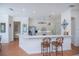 Open-concept kitchen with white cabinets, stainless steel appliances, and a large breakfast bar at 4308 Via Del Santi, Venice, FL 34293