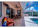 Covered lanai with comfortable seating, overlooking pool and the screened patio beyond at 4308 Via Del Santi, Venice, FL 34293