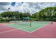 Exterior shot of tennis courts surrounded by mature landscaping at 4308 Via Del Santi, Venice, FL 34293