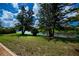 Scenic water view with mature pine trees and lush green lawn at 4308 Via Del Santi, Venice, FL 34293