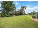 Large, well-maintained backyard featuring lush green grass, mature trees, and landscaping at 435 Boundary Blvd, Rotonda West, FL 33947