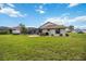 Expansive backyard with lush grass, mature trees, a screened pool, and outdoor patio at 435 Boundary Blvd, Rotonda West, FL 33947