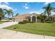 Beautiful single-story home with a well-manicured lawn and mature palm trees at 435 Boundary Blvd, Rotonda West, FL 33947