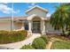 Close up of the home's entrance, highlighting the decorative doors and manicured garden at 435 Boundary Blvd, Rotonda West, FL 33947
