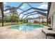 Screened pool area featuring a kidney-shaped pool, a lounge chair, and well-maintained landscaping at 435 Boundary Blvd, Rotonda West, FL 33947