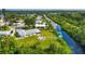 Waterfront home with lush backyard, firepit, boat dock, and canal views on a sunny day at 458 Ceil Ct, Nokomis, FL 34275