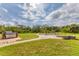 Large backyard with pavers, a built-in grill, Adirondack chairs around a fire pit, and a swing set at 458 Ceil Ct, Nokomis, FL 34275
