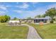 Outdoor patio featuring a fire pit with seating, lush green grass, and a charming walkway at 458 Ceil Ct, Nokomis, FL 34275