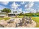 Backyard patio with outdoor seating around a stone fire pit, a built-in barbecue grill, and lush landscaping at 458 Ceil Ct, Nokomis, FL 34275