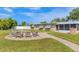 Backyard patio with a paved walkway, comfortable seating around a fire pit, a grill, and a screened-in porch at 458 Ceil Ct, Nokomis, FL 34275