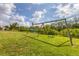 Spacious backyard with a swing set surrounded by lush greenery, offering endless possibilities for outdoor activities at 458 Ceil Ct, Nokomis, FL 34275