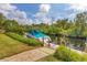 Waterfront property features a private boat dock with lush greenery, canal access, and sunny skies at 458 Ceil Ct, Nokomis, FL 34275