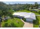 Charming home with a new white metal roof, lush green lawn, mature trees, and pristine landscaping at 458 Ceil Ct, Nokomis, FL 34275