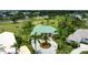Aerial view of a home with a teal roof and a circular driveway surrounded by a well-manicured green lawn at 467 Sherbrooke Ct, Venice, FL 34293