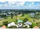 Aerial view of a home with teal roof surrounded by green grass and trees near a golf course at 467 Sherbrooke Ct, Venice, FL 34293