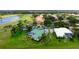 Aerial view of home with teal roof, pool, and screened lanai surrounded by lush landscaping and a golf course at 467 Sherbrooke Ct, Venice, FL 34293
