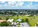 Aerial view of a home with a teal roof surrounded by trees near a golf course and other homes at 467 Sherbrooke Ct, Venice, FL 34293