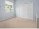 Well-lit bedroom with neutral carpet, and double closet doors perfect for ample storage at 467 Sherbrooke Ct, Venice, FL 34293