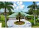 An exterior view of a home with a teal roof, a circular driveway, and a large palm tree in the center at 467 Sherbrooke Ct, Venice, FL 34293