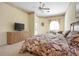 Spacious primary bedroom with carpeting, a TV, ceiling fan, and ensuite bath at 467 Sherbrooke Ct, Venice, FL 34293