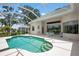 A screened-in pool with teal water is surrounded by a white patio and home with an open view of the lawn at 467 Sherbrooke Ct, Venice, FL 34293