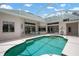 A screened in pool with teal water is surrounded by a white patio and white house with large sliding glass doors at 467 Sherbrooke Ct, Venice, FL 34293