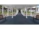 Covered walkway with white columns and manicured gardens, offering a serene and inviting pathway at 467 Sherbrooke Ct, Venice, FL 34293