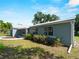 Exterior of the home with attached garage, metal roof, and mature landscaping at 4688 Maraldo Ave, North Port, FL 34287
