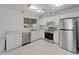 Well-lit kitchen featuring white cabinets, stainless steel appliances, and tile flooring at 4688 Maraldo Ave, North Port, FL 34287